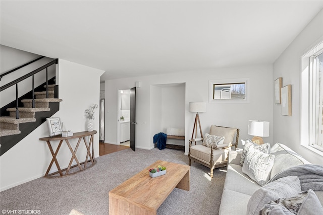 living area featuring a wealth of natural light, baseboards, carpet floors, and stairs