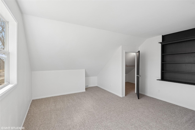 bonus room featuring baseboards, lofted ceiling, and carpet floors