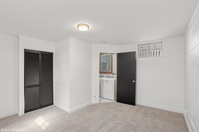 unfurnished bedroom featuring light carpet, baseboards, a closet, and separate washer and dryer