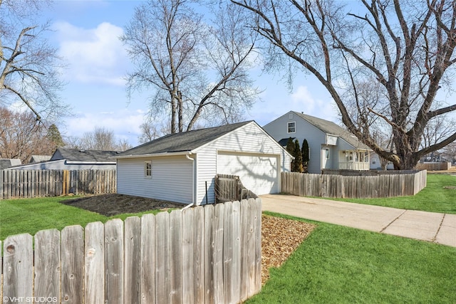 view of home's exterior featuring an outbuilding, a lawn, driveway, and a fenced front yard