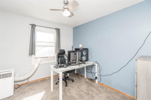 carpeted office featuring baseboards, a textured ceiling, and ceiling fan