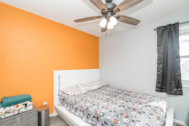 carpeted bedroom featuring baseboards and a ceiling fan