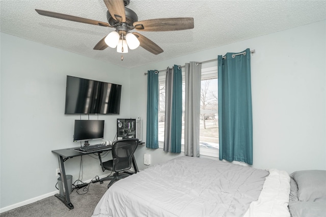 bedroom with baseboards, carpet floors, a textured ceiling, and a ceiling fan