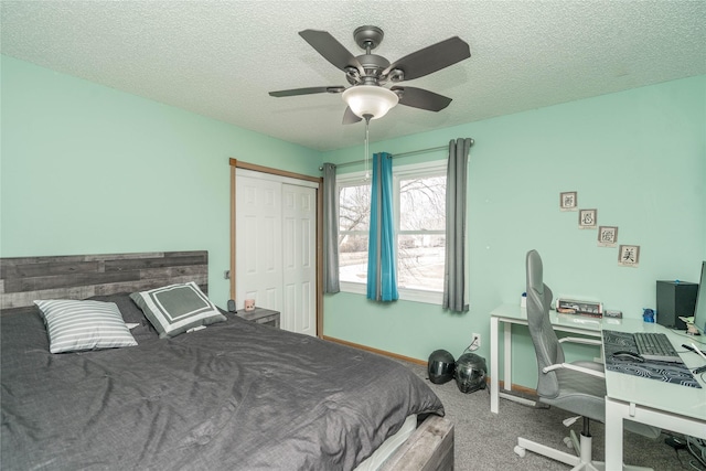 carpeted bedroom with a closet, ceiling fan, a textured ceiling, and baseboards