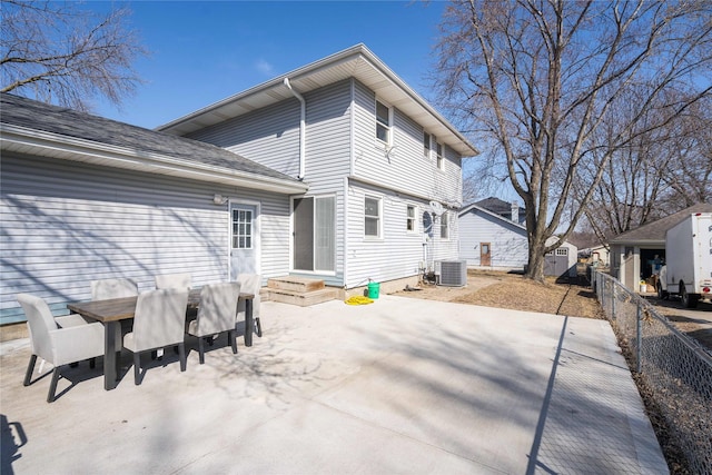 back of property with central AC unit, outdoor dining area, fence, and a patio area