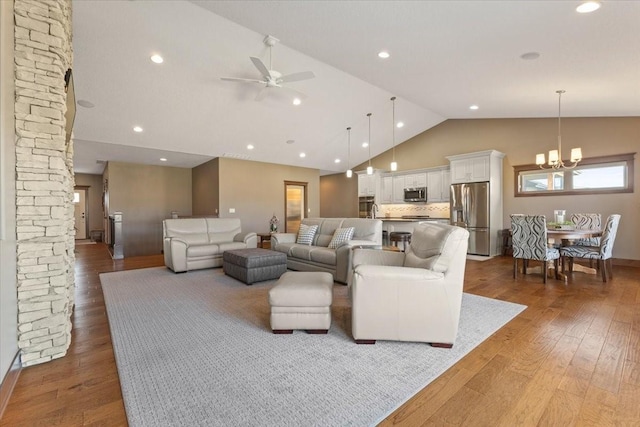 living room with recessed lighting, wood-type flooring, high vaulted ceiling, and ceiling fan with notable chandelier