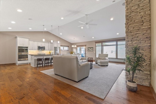 living area featuring baseboards, wood finished floors, a healthy amount of sunlight, and ceiling fan