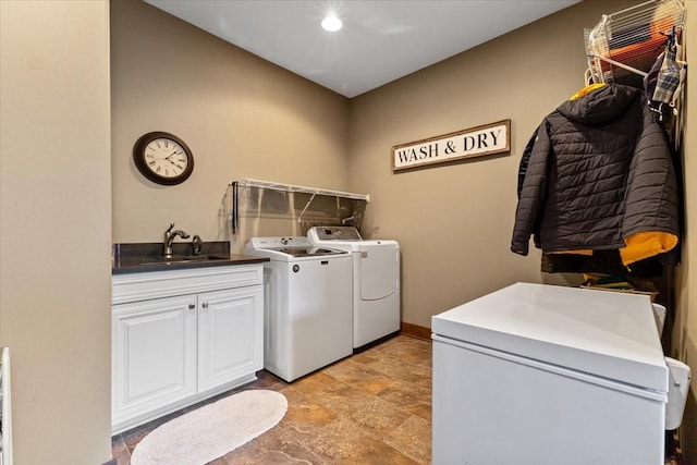 washroom with independent washer and dryer, stone finish floor, a sink, cabinet space, and baseboards