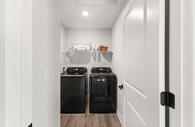 laundry room with washing machine and clothes dryer, laundry area, and wood finished floors