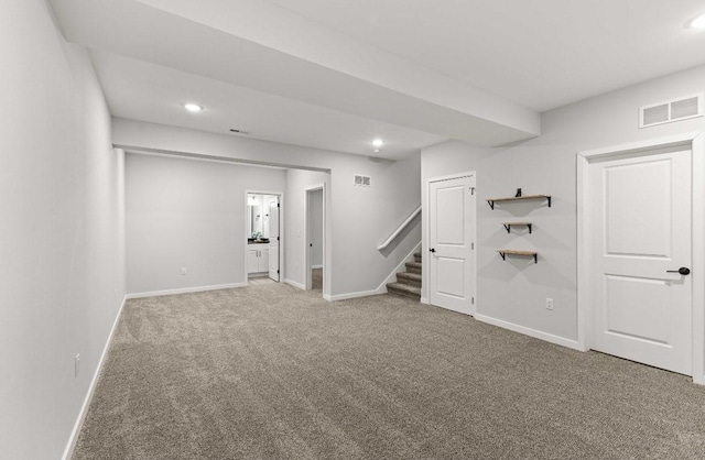 below grade area featuring stairway, visible vents, baseboards, carpet floors, and recessed lighting