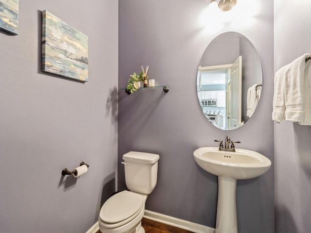 bathroom featuring toilet and baseboards