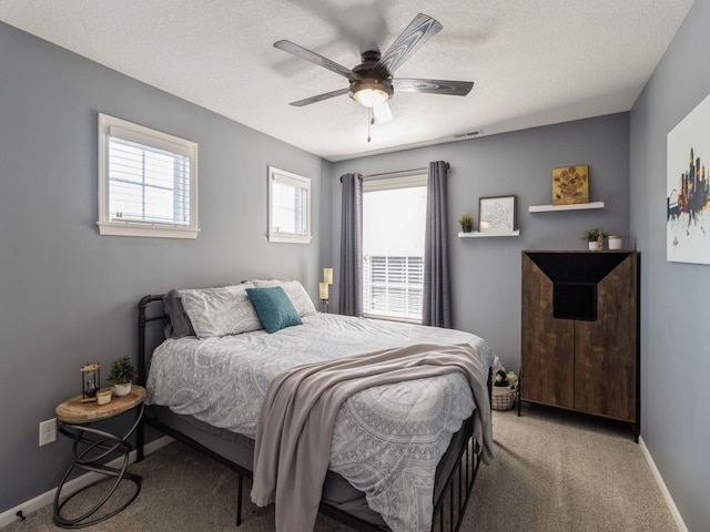 bedroom with ceiling fan, a textured ceiling, baseboards, and carpet floors