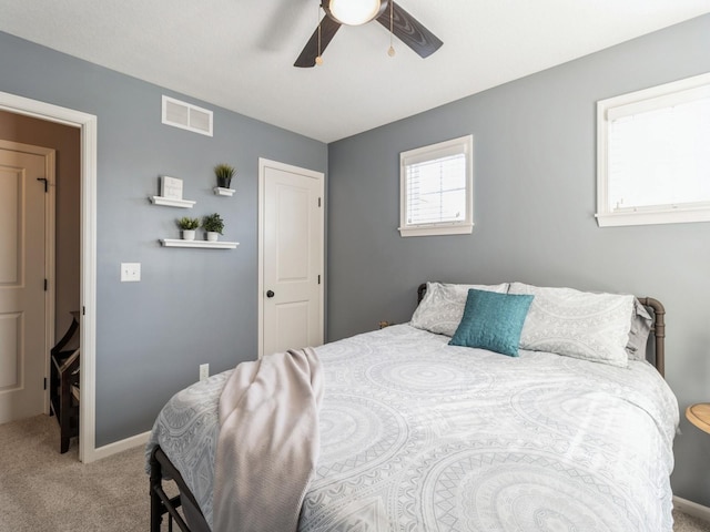 carpeted bedroom with baseboards, visible vents, and ceiling fan