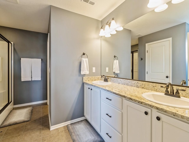 bathroom with tile patterned flooring, double vanity, a stall shower, and a sink