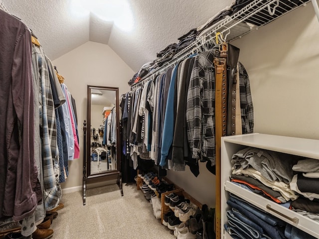 walk in closet featuring carpet and vaulted ceiling