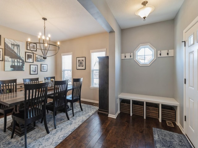 dining space with baseboards, a notable chandelier, and hardwood / wood-style flooring