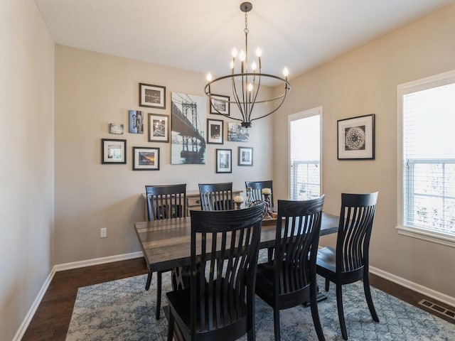 dining room featuring a notable chandelier, baseboards, visible vents, and dark wood-style flooring