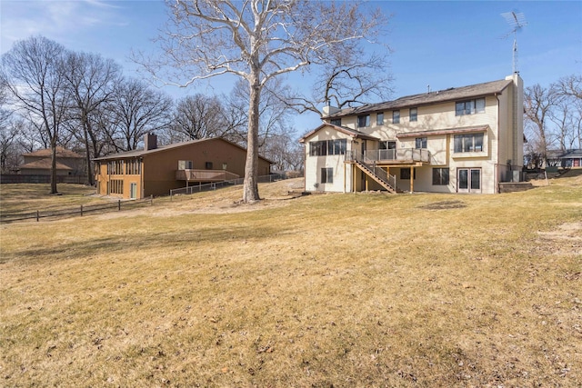 back of house featuring stairway, a yard, a deck, and fence