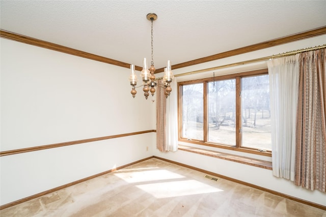 carpeted spare room featuring crown molding, visible vents, a chandelier, and a textured ceiling