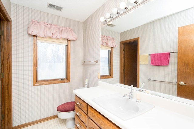 bathroom featuring vanity, toilet, and visible vents