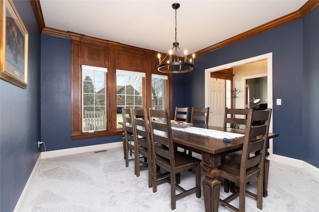 dining room featuring a notable chandelier, light colored carpet, crown molding, and baseboards