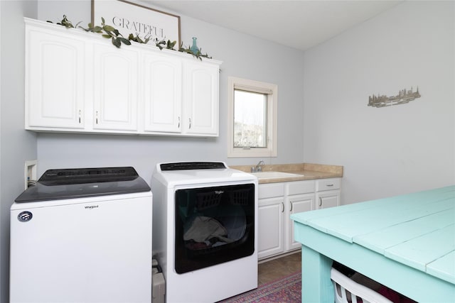 laundry room with cabinet space, independent washer and dryer, and a sink