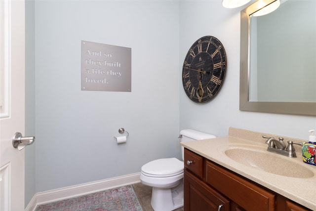 half bathroom with tile patterned floors, baseboards, toilet, and vanity