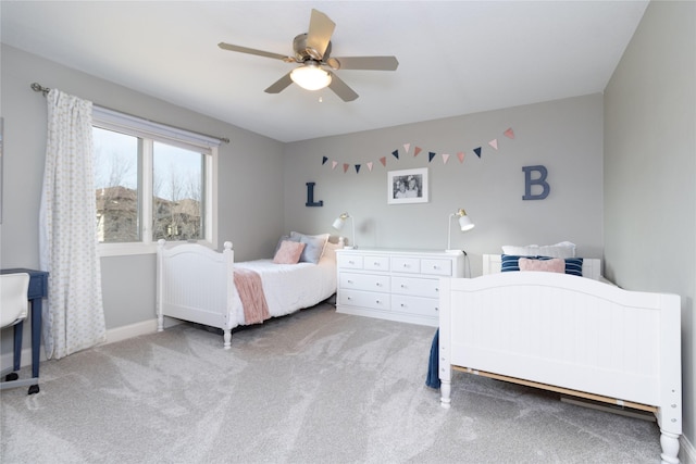 carpeted bedroom with baseboards and a ceiling fan