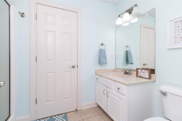 bathroom featuring vanity, tile patterned floors, toilet, and baseboards