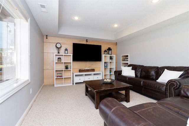 living area featuring visible vents, baseboards, carpet flooring, recessed lighting, and a raised ceiling