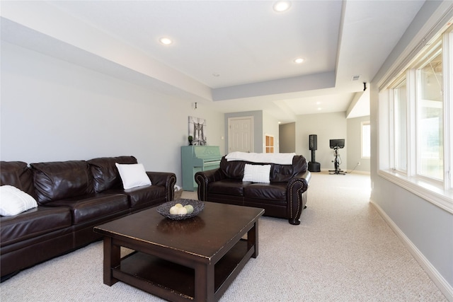 living area featuring a tray ceiling, recessed lighting, light colored carpet, and baseboards