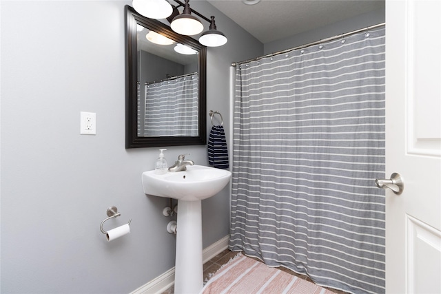 full bath featuring tile patterned floors and baseboards