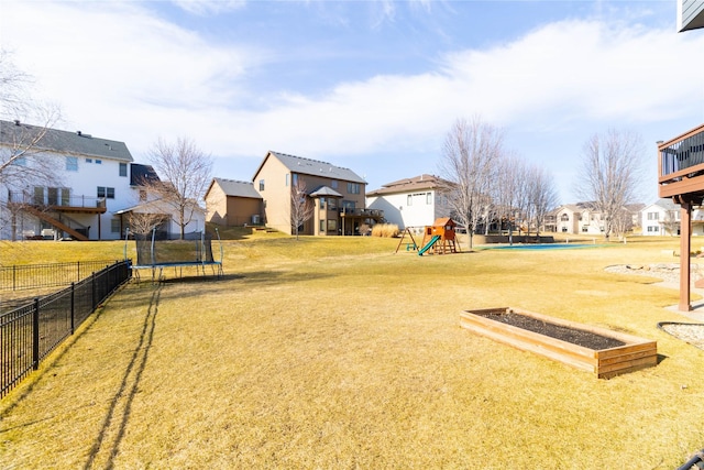 view of yard featuring a residential view, playground community, a trampoline, and fence