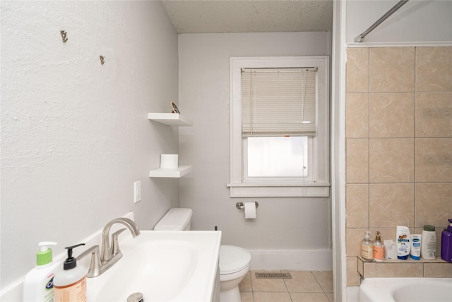 bathroom featuring visible vents, toilet, tile patterned floors, a textured ceiling, and a sink