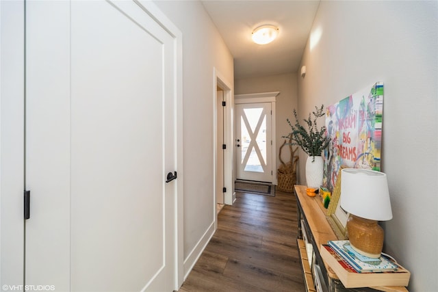 hallway with dark wood-type flooring and baseboards