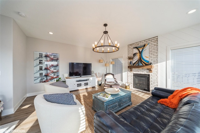 living room with an inviting chandelier, recessed lighting, wood finished floors, and baseboards