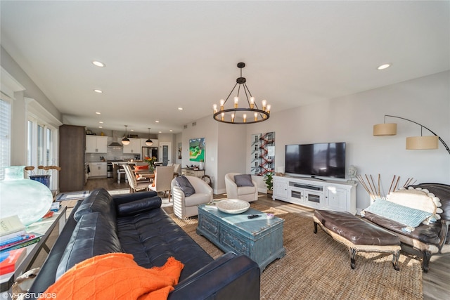 living area with recessed lighting, an inviting chandelier, and wood finished floors