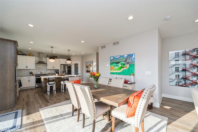 dining area with recessed lighting, wood finished floors, and visible vents