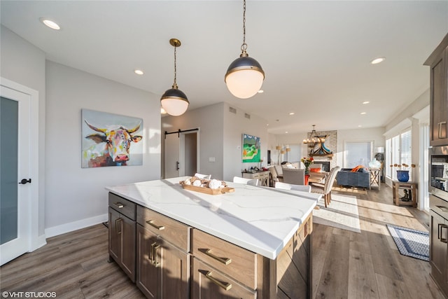 kitchen with recessed lighting, a barn door, and dark wood-style floors