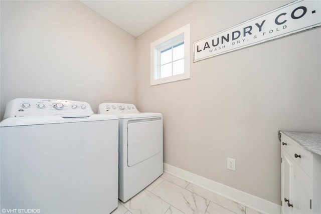 laundry area featuring baseboards, cabinet space, marble finish floor, and washer and clothes dryer