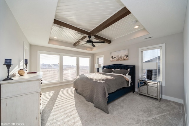 bedroom with visible vents, a raised ceiling, baseboards, light colored carpet, and ceiling fan