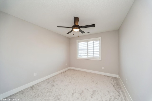 carpeted spare room featuring visible vents, a ceiling fan, baseboards, and a textured ceiling