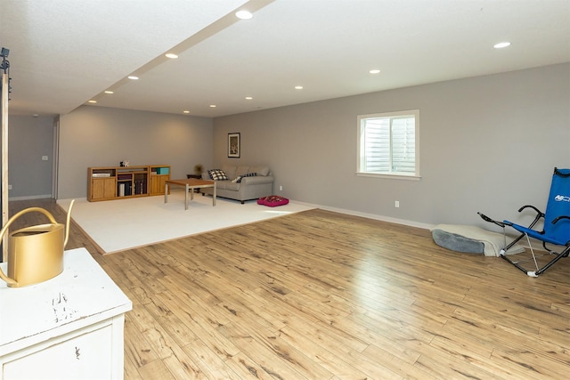 living area with recessed lighting, baseboards, and light wood-style flooring