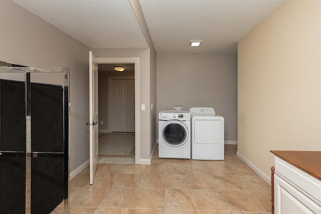 laundry room with laundry area, a textured ceiling, baseboards, and separate washer and dryer