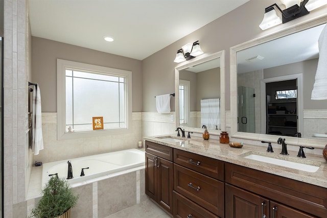 bathroom with a sink, visible vents, a garden tub, and a stall shower