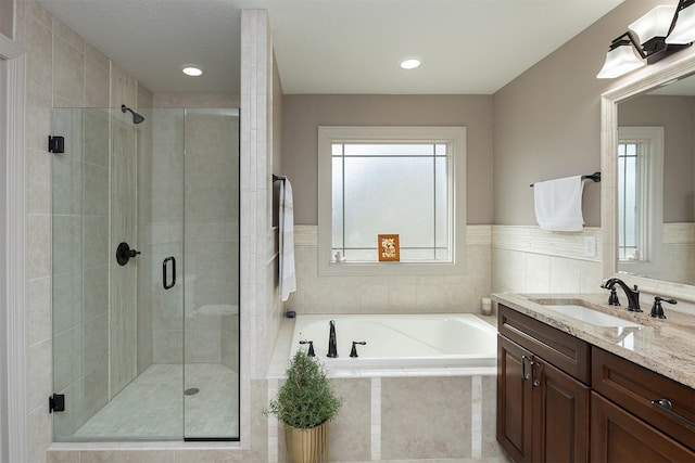 full bathroom featuring vanity, a shower stall, and a garden tub