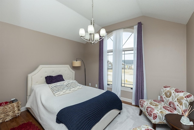 bedroom with an inviting chandelier, vaulted ceiling, wood finished floors, and baseboards