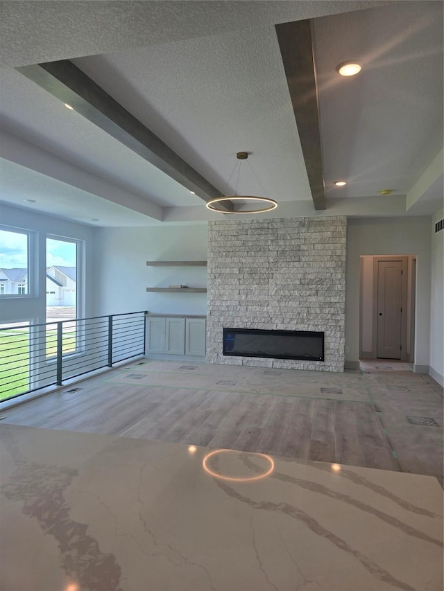 16203 Goodman Dr, Urbandale, IA 50323 - unfurnished living room with a stone fireplace, wood finished floors, recessed lighting, and beam ceiling