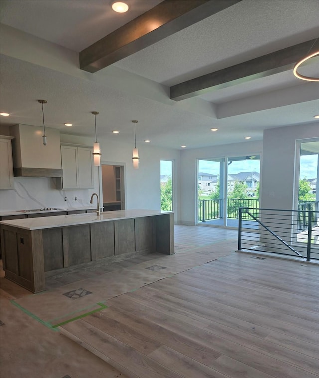 16203 Goodman Dr, Urbandale, IA 50323 - kitchen with custom exhaust hood, beam ceiling, healthy amount of natural light, recessed lighting, and a large island with sink