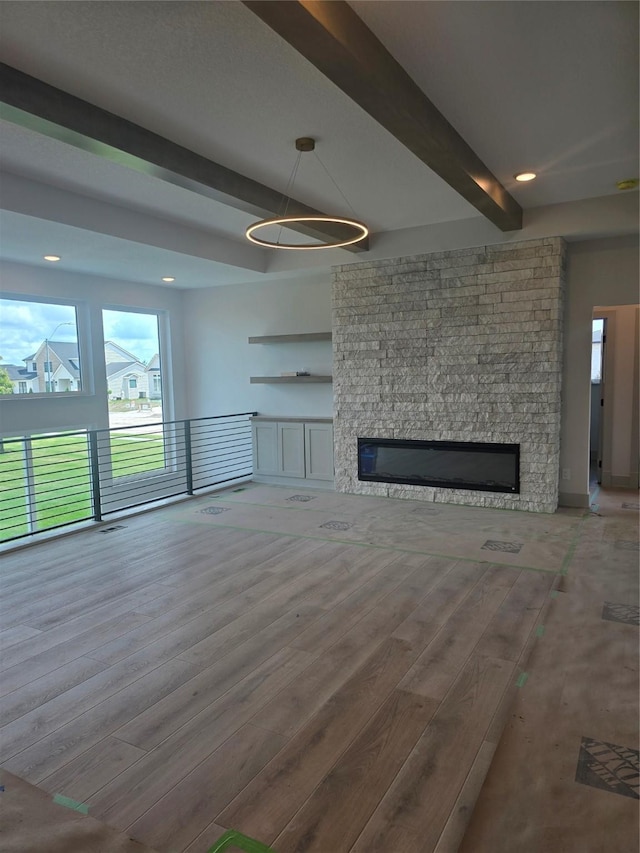 16203 Goodman Dr, Urbandale, IA 50323 - unfurnished living room with beam ceiling, a fireplace, wood finished floors, and recessed lighting